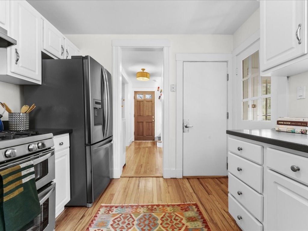 55 Coolidge Road Arlington, MA 02476 - Photo 19 of 42 a kitchen with granite countertop a refrigerator and a stove top oven