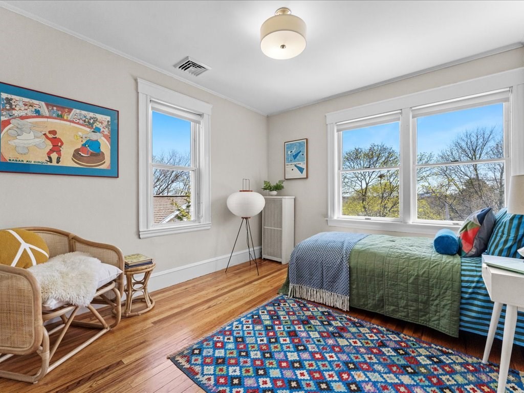 55 Coolidge Road Arlington, MA 02476 - Photo 22 of 42 a bedroom with a bed and wooden floor
