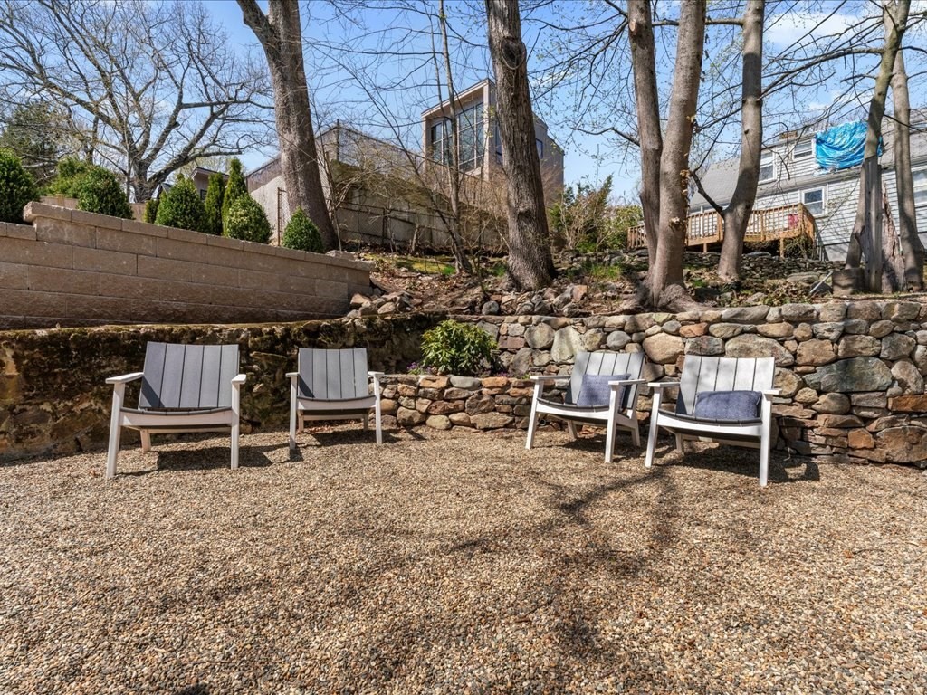 55 Coolidge Road Arlington, MA 02476 - Photo 31 of 42 a view of a backyard with table and chairs with wooden fence and plants