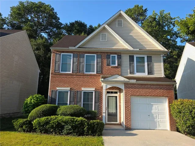 a front view of a house with yard and green space
