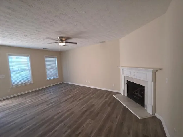 an empty room with windows and fireplace