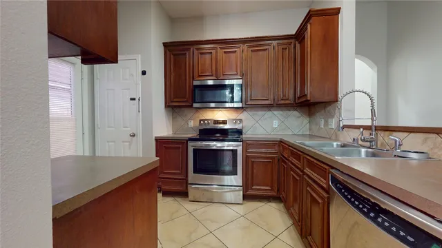 a kitchen with granite countertop a sink stove and microwave