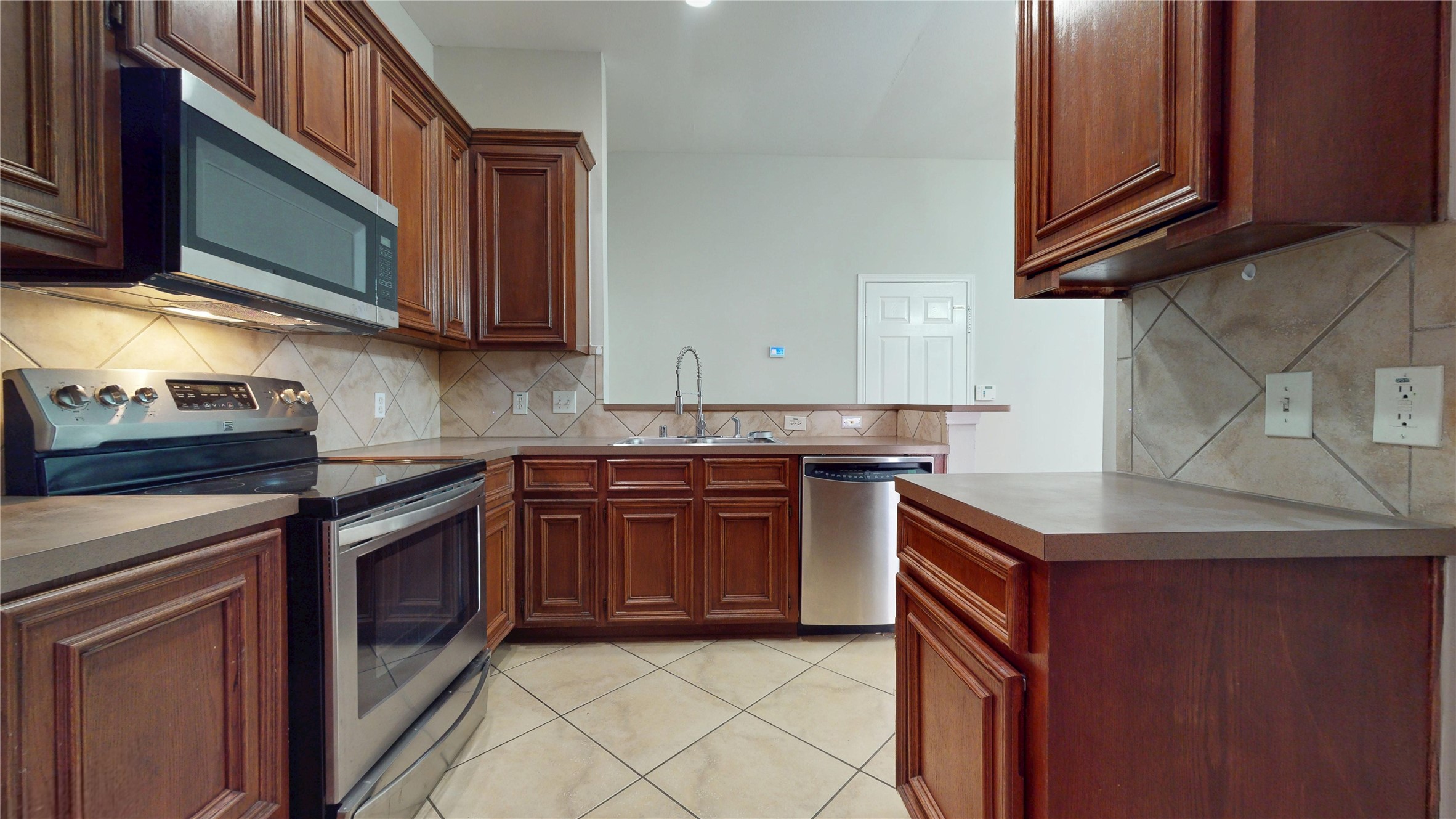 16611 Cheshire Grove Lane Houston, TX 77090 - Photo 15 of 40 a kitchen with stainless steel appliances granite countertop a stove microwave and sink