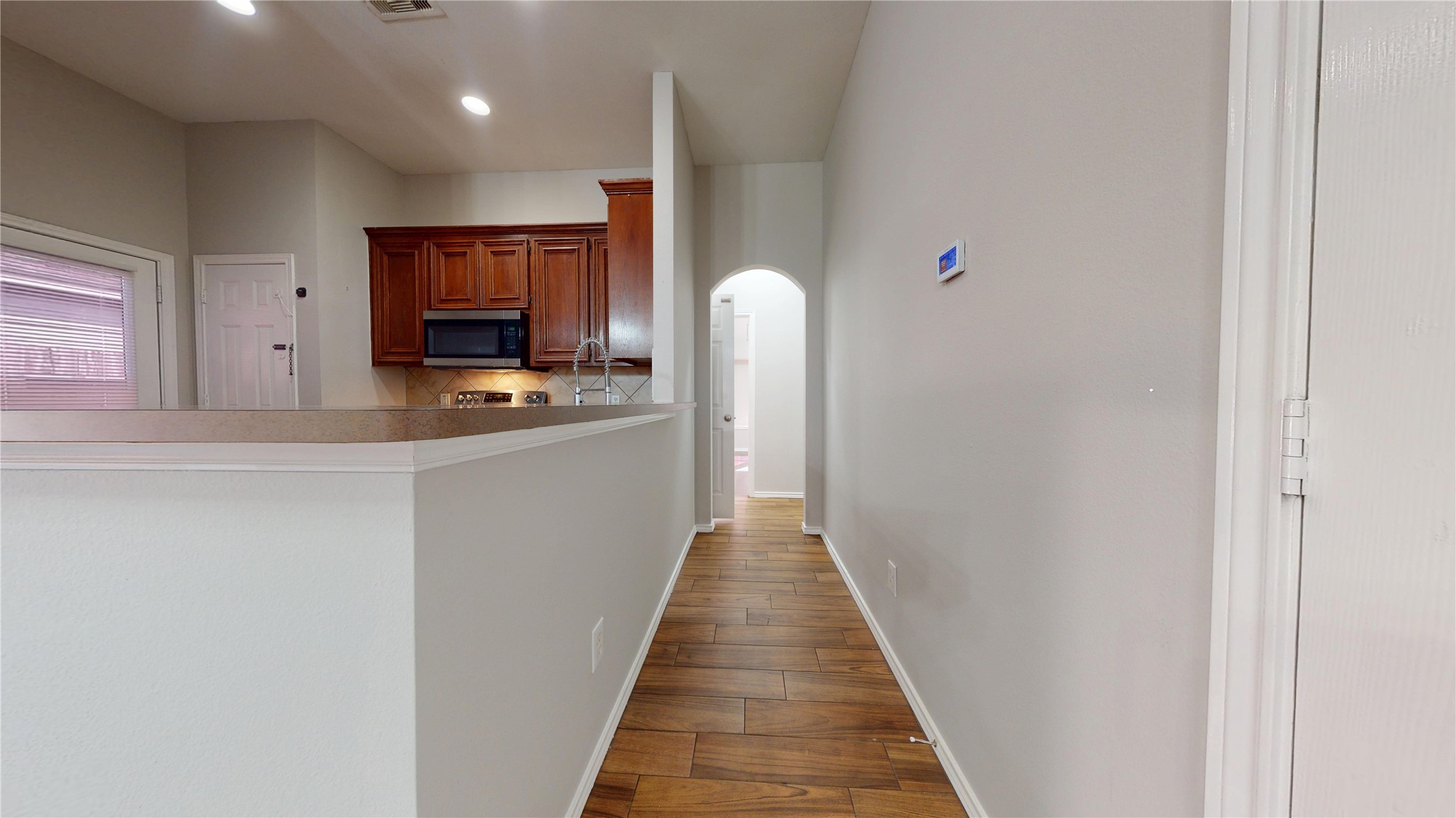 16611 Cheshire Grove Lane Houston, TX 77090 - Photo 18 of 40 a hallway with stainless steel appliances a sink and a refrigerator