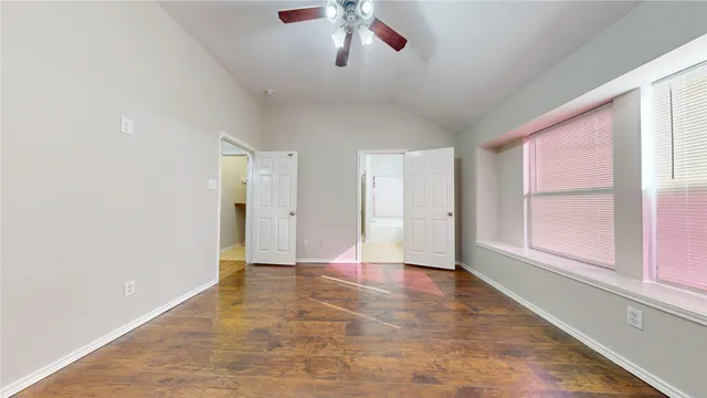 a spacious bathroom with a tub mirror and toilet