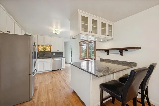 a kitchen with stainless steel appliances granite countertop a stove a refrigerator a oven a sink with island and chairs