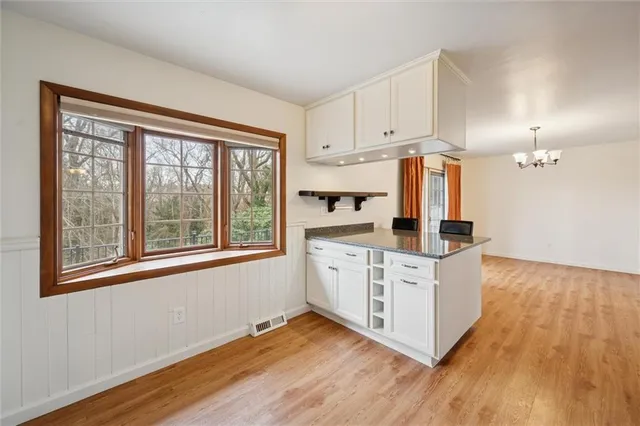 a kitchen with stainless steel appliances a stove top oven and a wooden floor