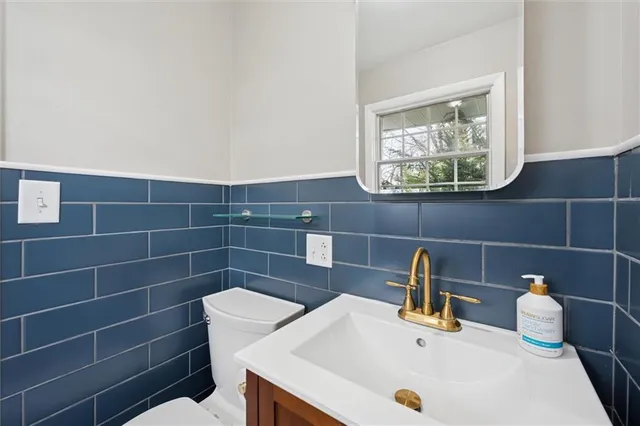 a bathroom with a sink a toilet and a mirror