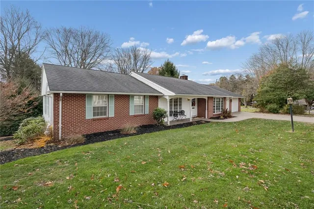 a front view of a house with yard and green space