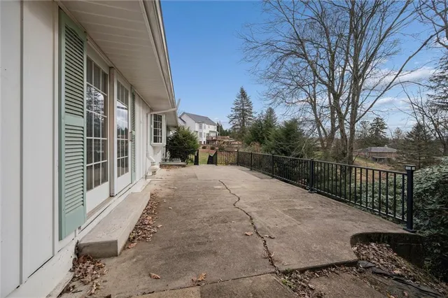 a front view of a house with a large tree