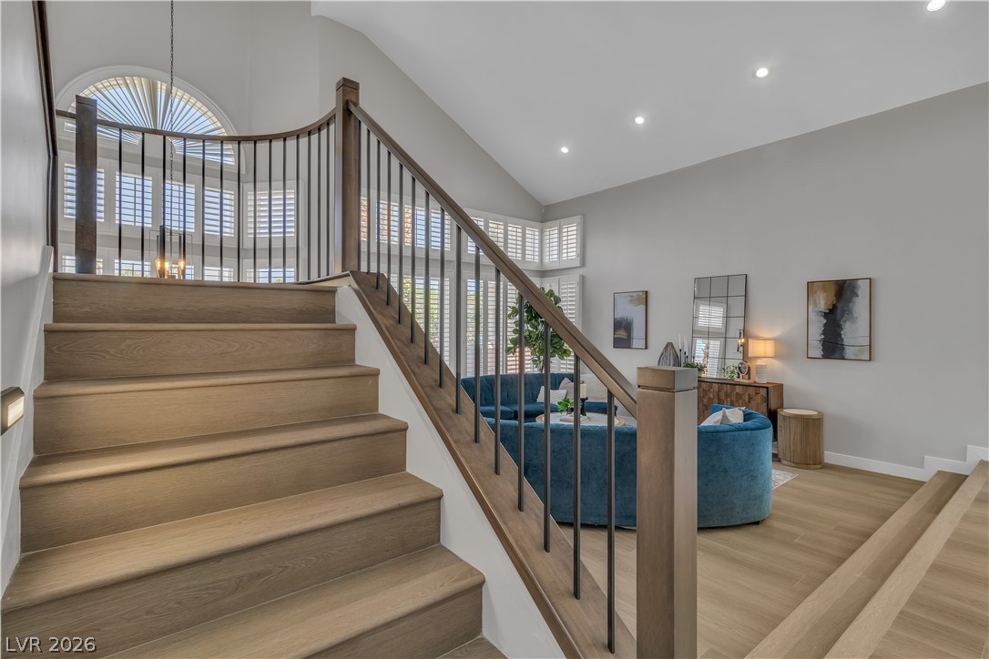 8848 Rainbow Ridge Drive Las Vegas, NV 89117 - Photo 18 of 43 Grand staircase with contemporary railings frames a welcoming entry to the open-concept living space.