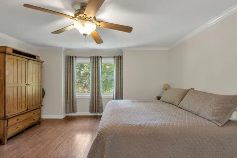 a large bedroom with a bed and a large window with wooden floor