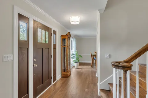 a view of a hallway with wooden floor and staircase