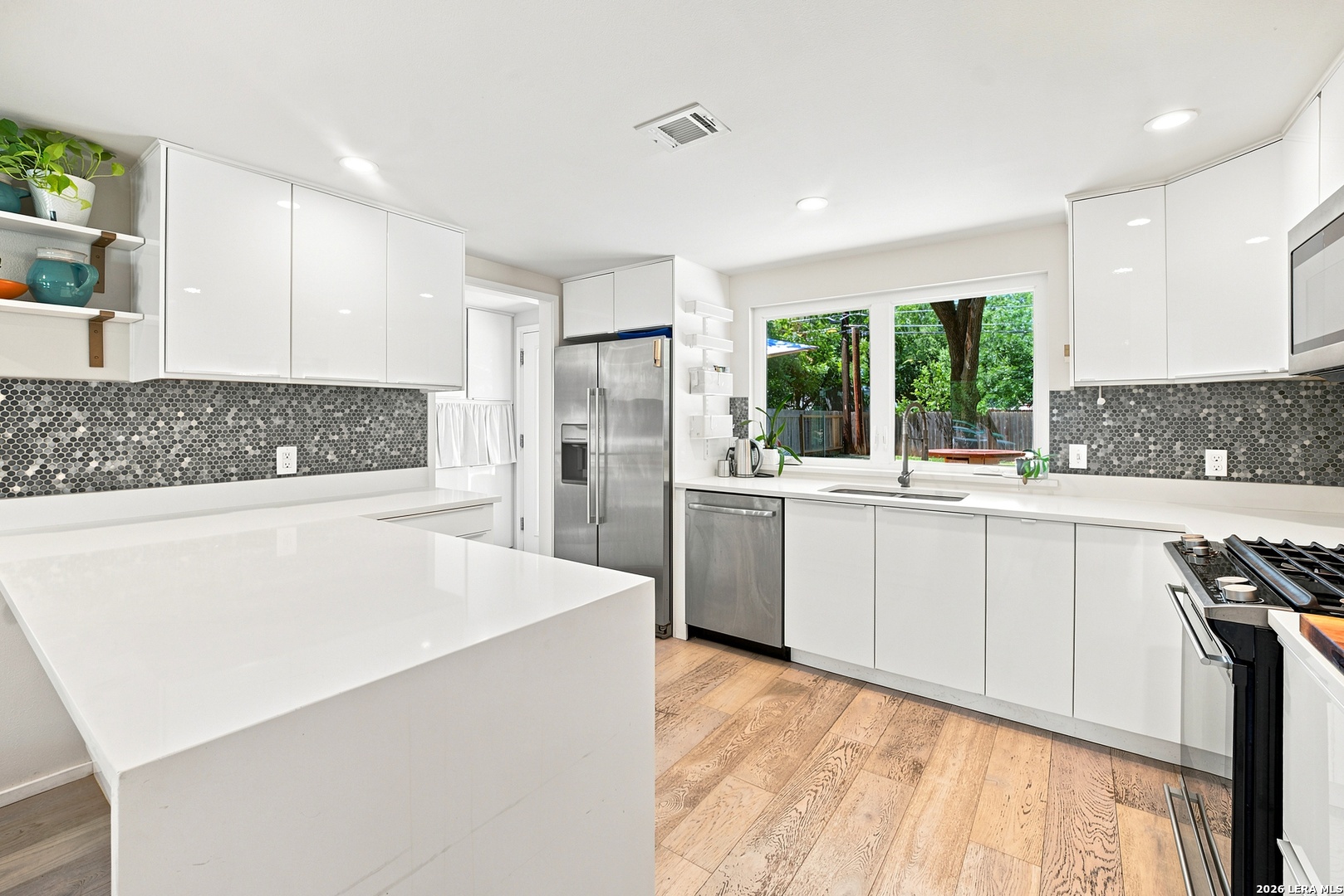 4610 Tanney Street Austin, TX 78721 - Photo 8 of 27 a kitchen with white cabinets and white appliances