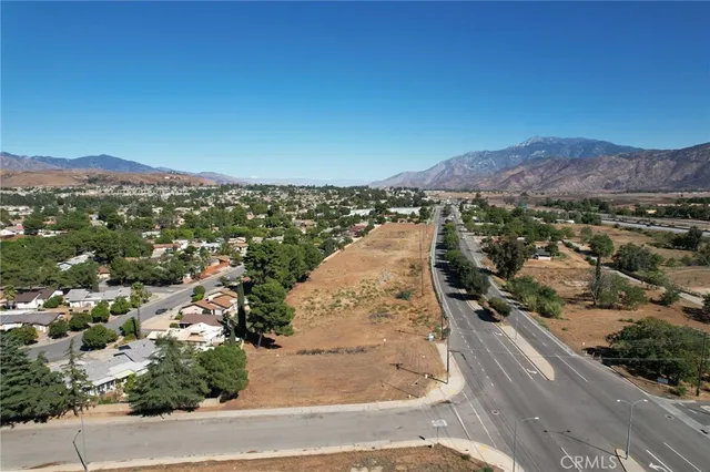 an aerial view of residential houses with outdoor space and street view