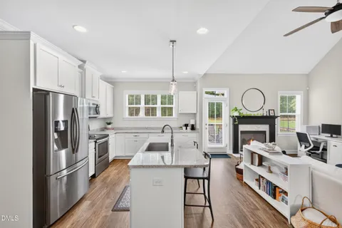 a kitchen with cabinets a sink a counter space stainless steel appliances and a window