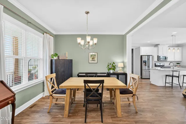 a dining room with furniture a chandelier and wooden floor