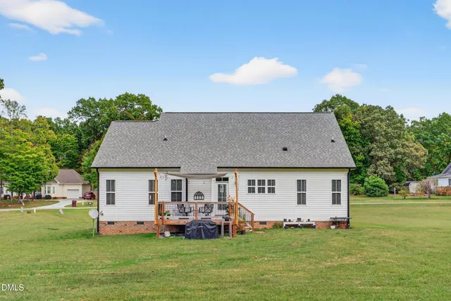 a front view of a house with a garden and trees