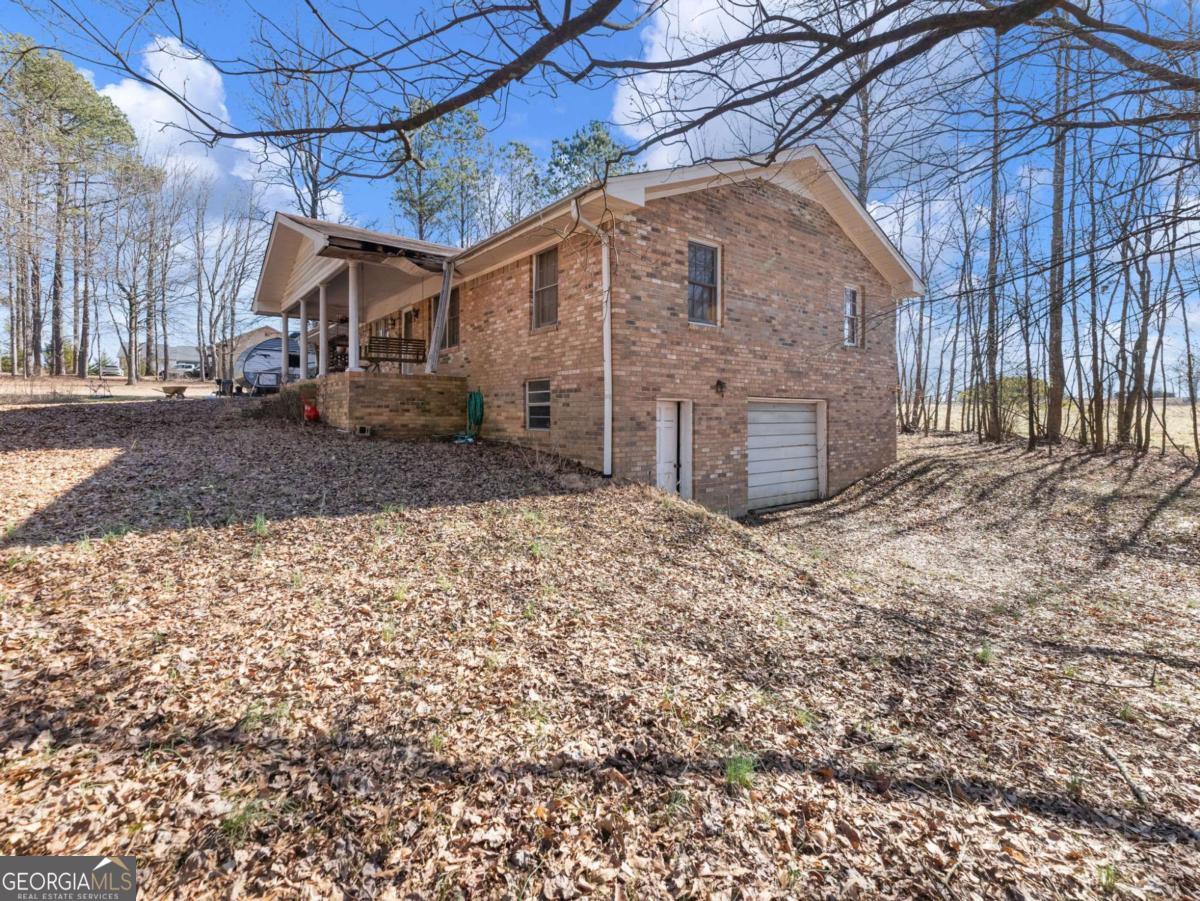 5539 McEver Road Flowery Branch, GA 30542 - Photo 22 of 41 a view of a grey house with a large tree