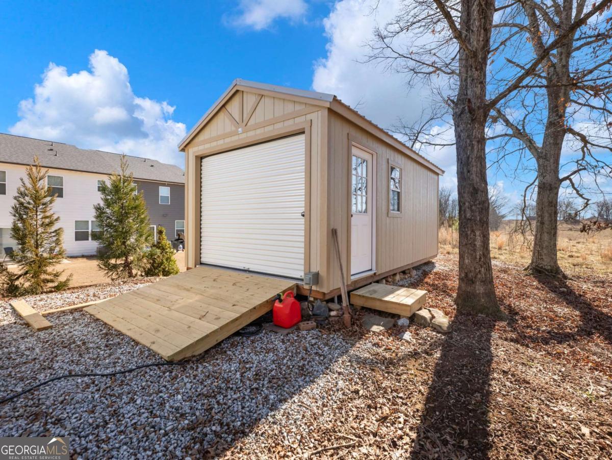 5539 McEver Road Flowery Branch, GA 30542 - Photo 4 of 41 a backyard of a house with wooden floor and fence