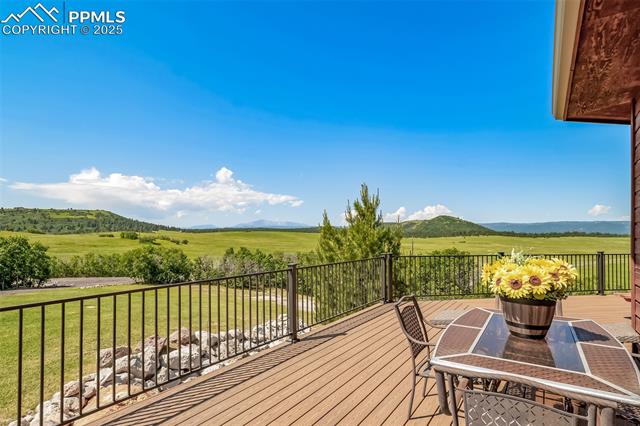 4586 East Best Road Larkspur, CO 80118 - Photo 40 of 50 Wooden deck with a mountain view, a view of countryside, and a lawn