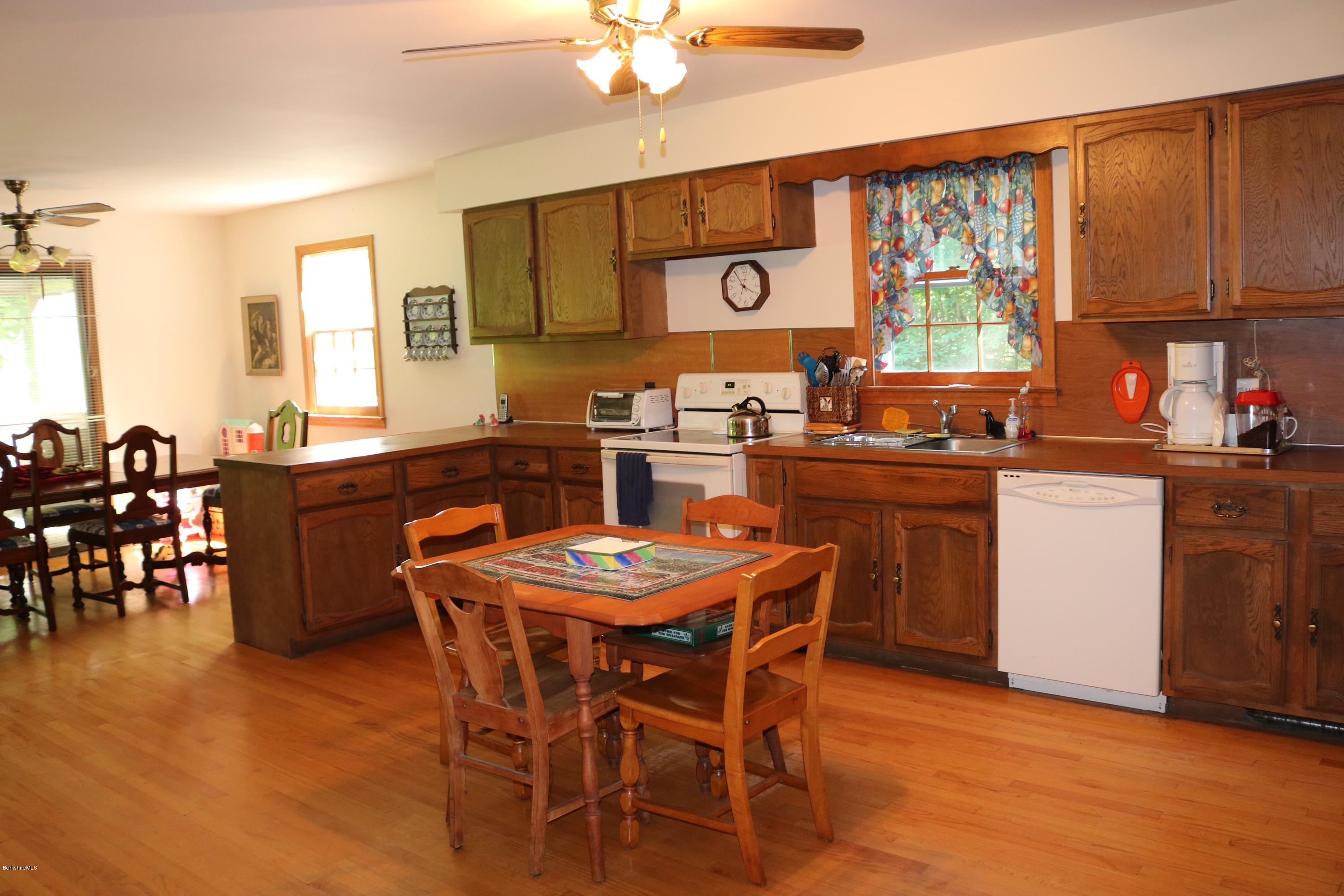 2401 West Center Road Otis, MA 01253 - Photo 4 of 24 a kitchen with a table chairs stove and microwave