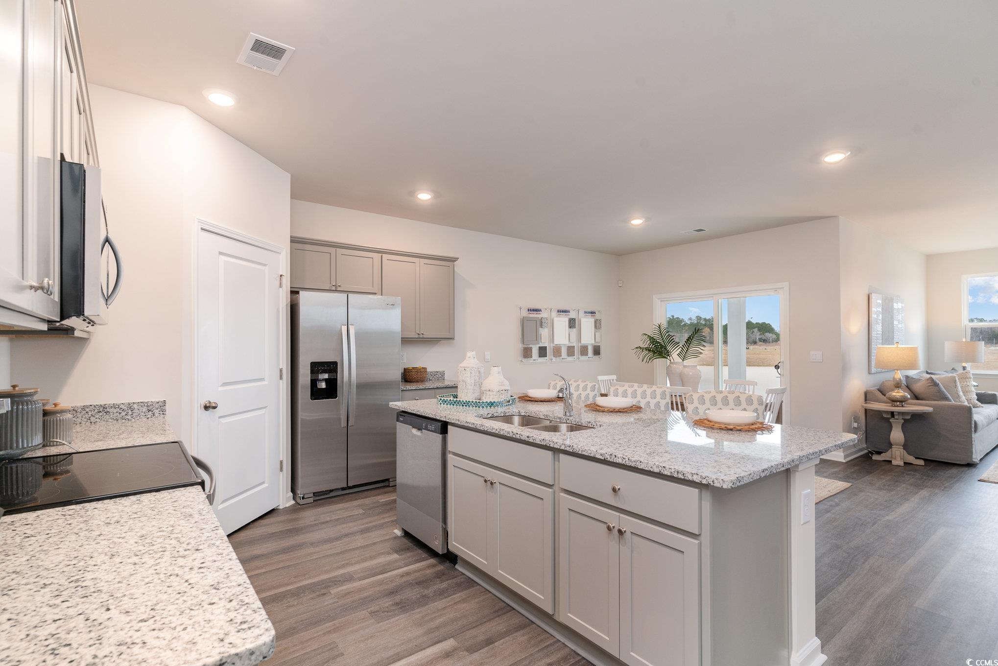 7367 Meadow Walk Loop Loris, SC 29569 - Photo 25 of 25 Kitchen featuring a sink, stainless steel appliances, open floor plan, wood finished floors, and gray cabinetry