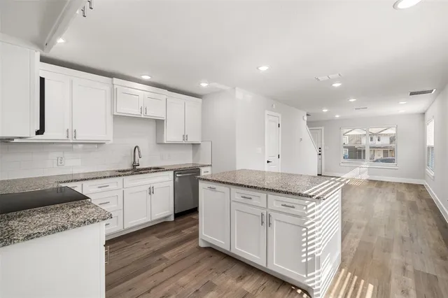 a kitchen with granite countertop white cabinets and white appliances