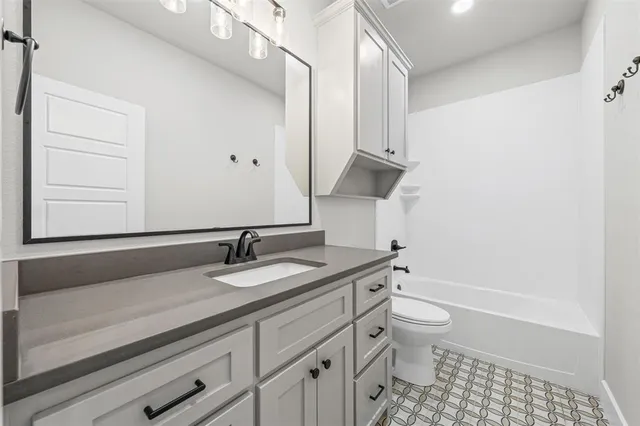 a bathroom with a granite countertop sink a toilet and a bathtub