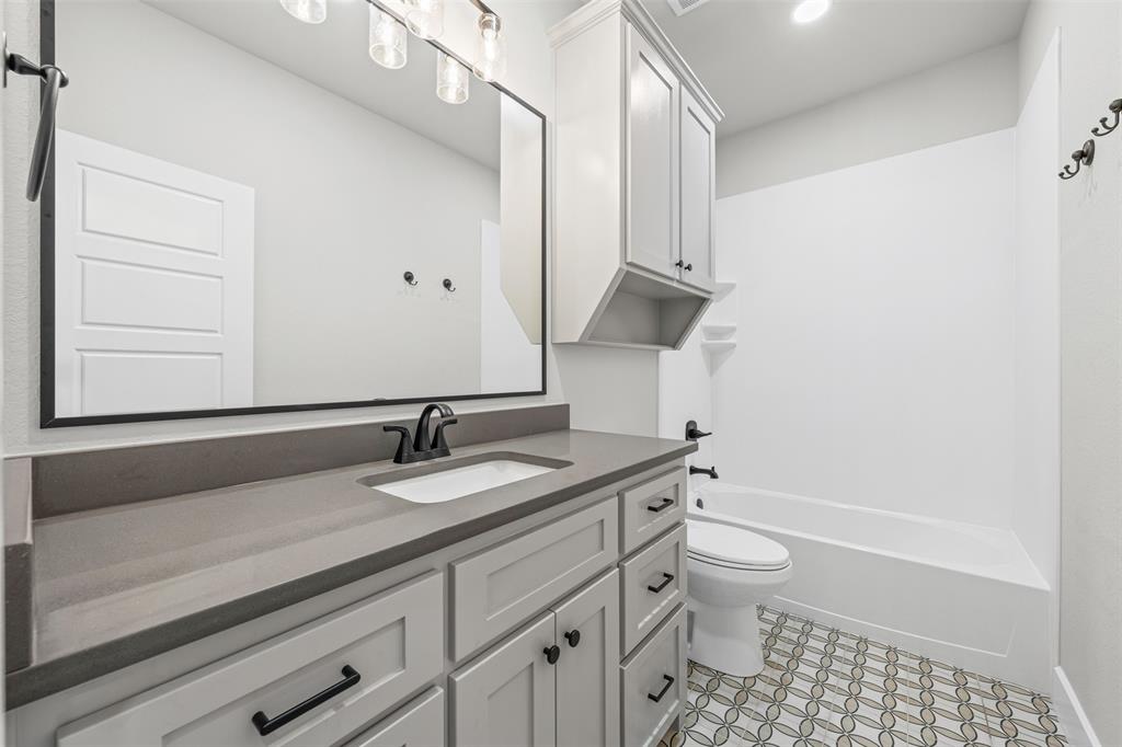 825 Forward Pass Drive Hewitt, TX 76643 - Photo 12 of 37 a bathroom with a granite countertop sink a toilet and a bathtub