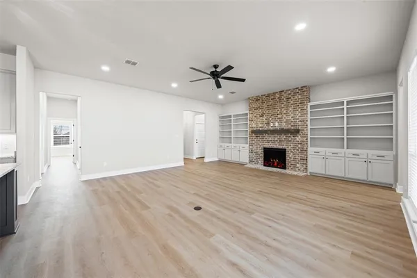 a view of an empty room with a fireplace and a window
