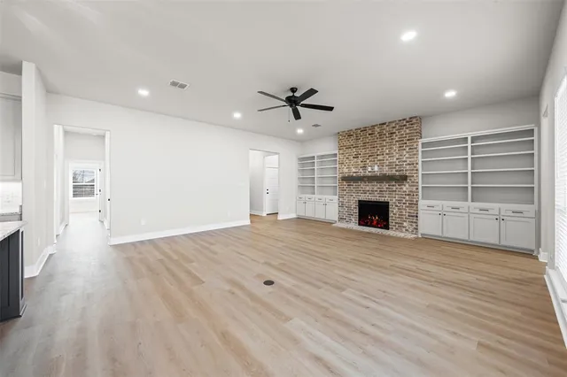 a view of an empty room with a fireplace and a window