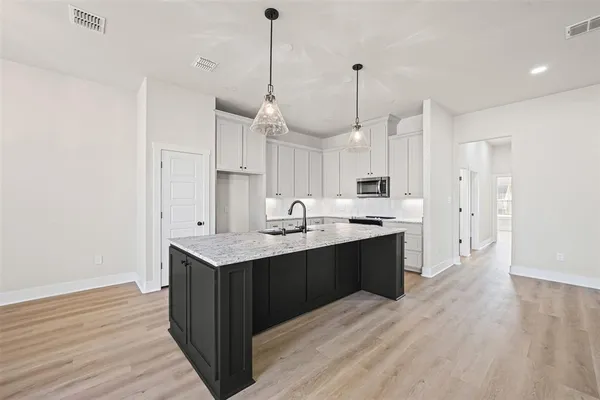 a large kitchen with stainless steel appliances kitchen island a wooden floor
