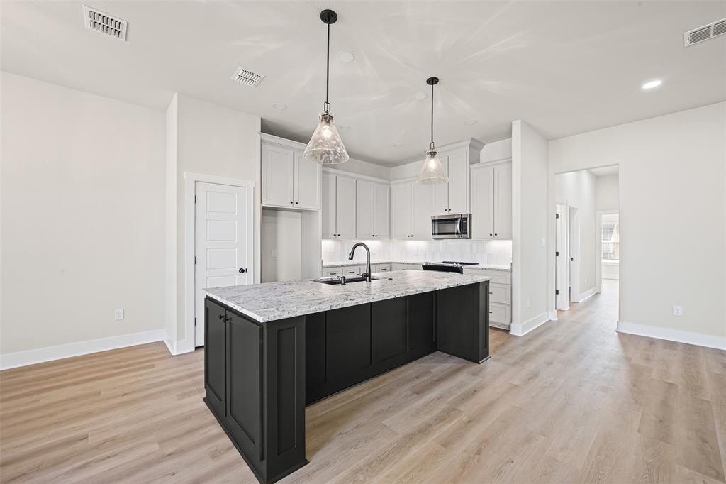 825 Forward Pass Drive Hewitt, TX 76643 - Photo 20 of 37 a large kitchen with stainless steel appliances kitchen island a wooden floor