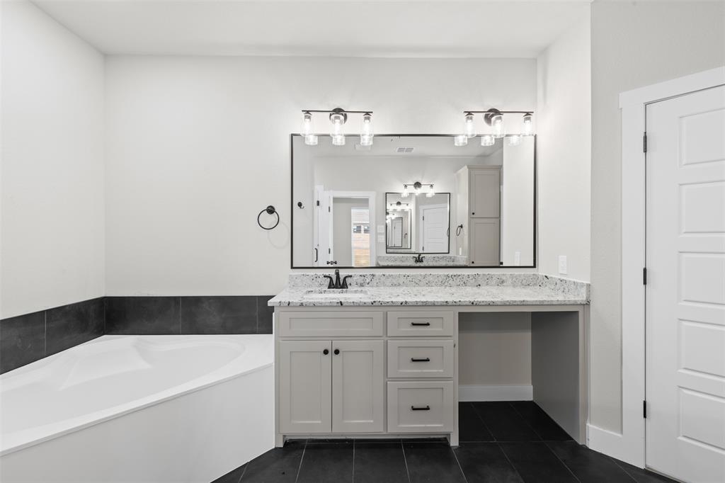 825 Forward Pass Drive Hewitt, TX 76643 - Photo 30 of 37 a bathroom with a granite countertop sink a bathtub a mirror and vanity