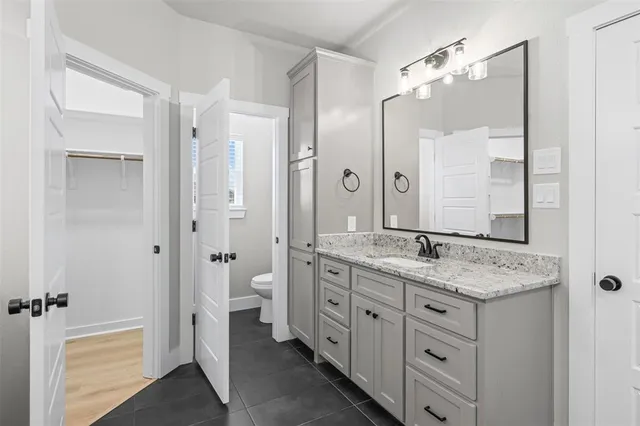 a bathroom with a granite countertop sink double and mirror