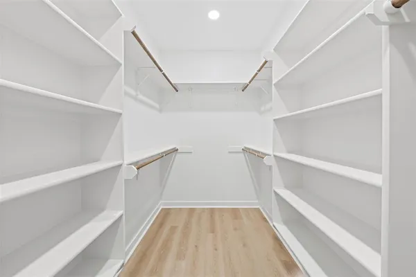 a view of walk in closet with empty racks