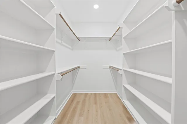 a view of walk in closet with empty racks