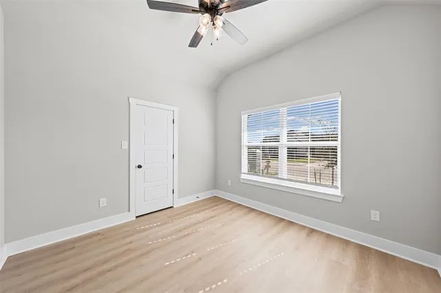 an empty room with a window and ceiling fan