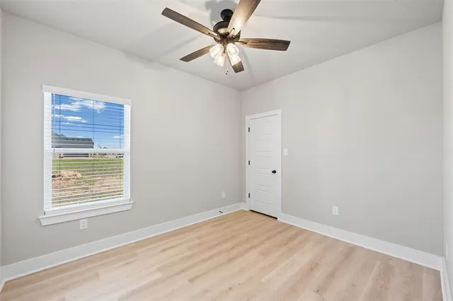 a view of a room with a ceiling fan and a hardwood floor