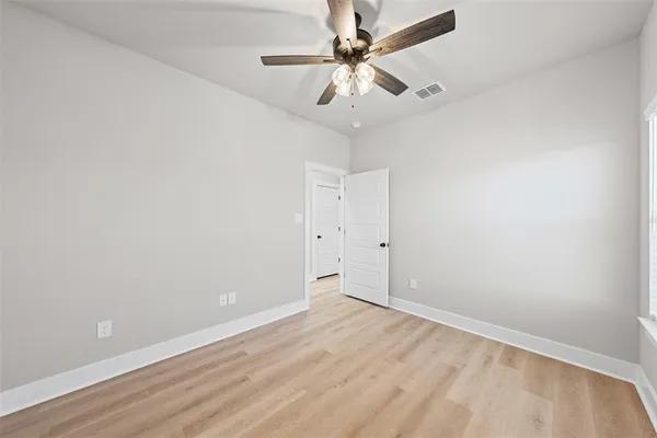 an empty room with a window and a fan