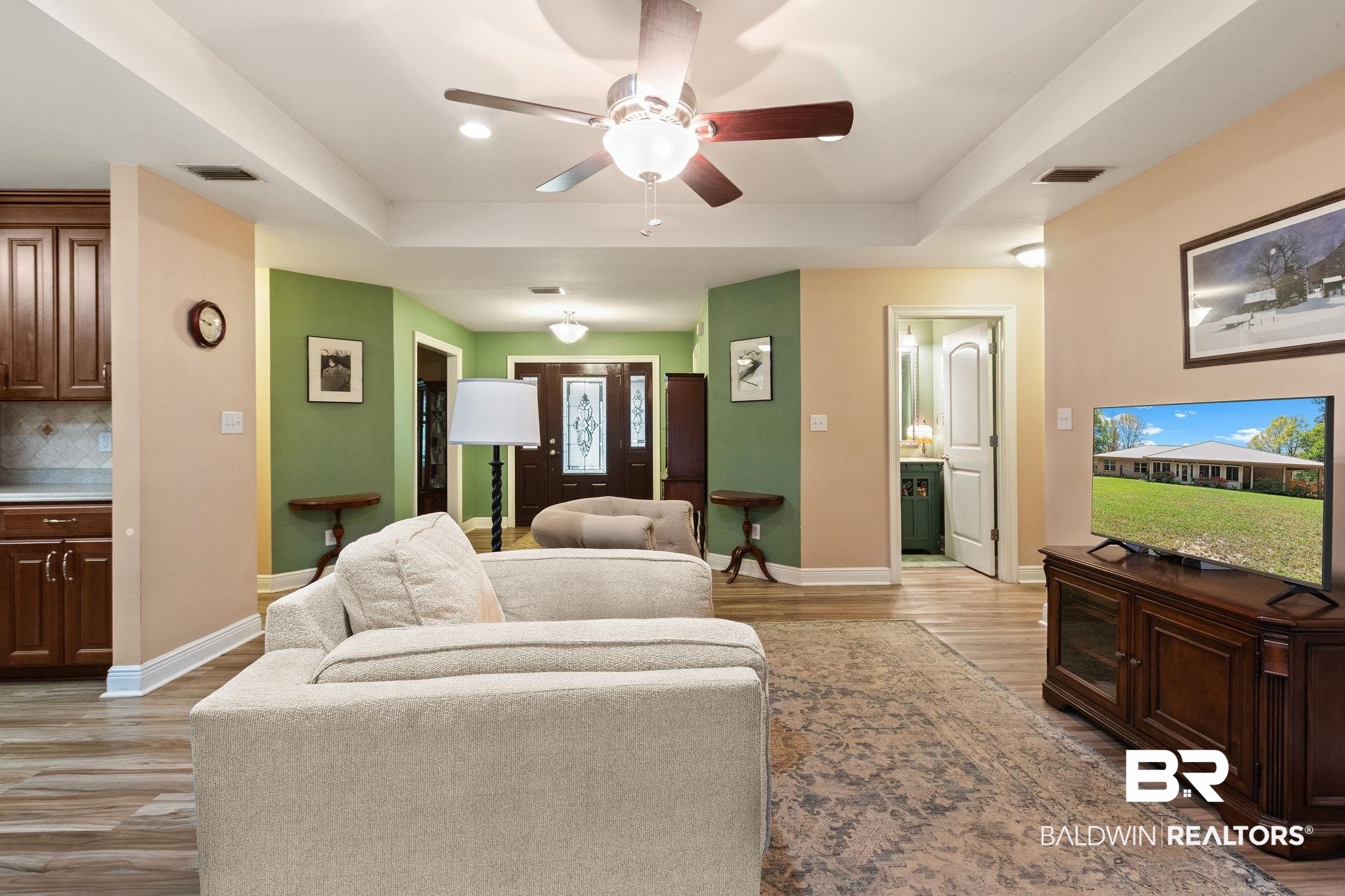 24250 Hack Road Bay Minette, AL 36507 - Photo 11 of 88 Living room featuring ceiling fan, light wood-style floors, and a raised ceiling
