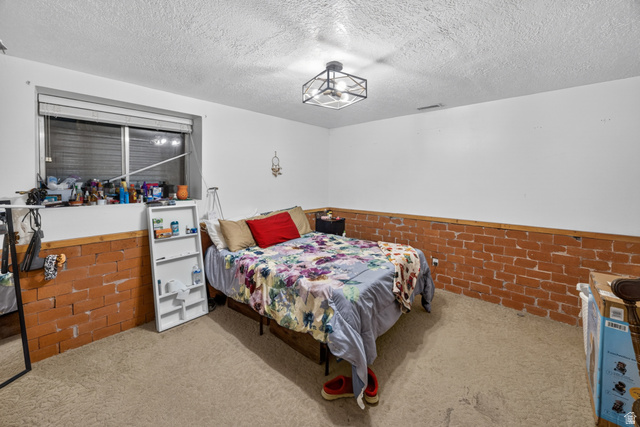 1218 East 100 South Logan, UT 84321 - Photo 20 of 23 Room featuring carpet flooring and white walls with a brick wainscoting detail