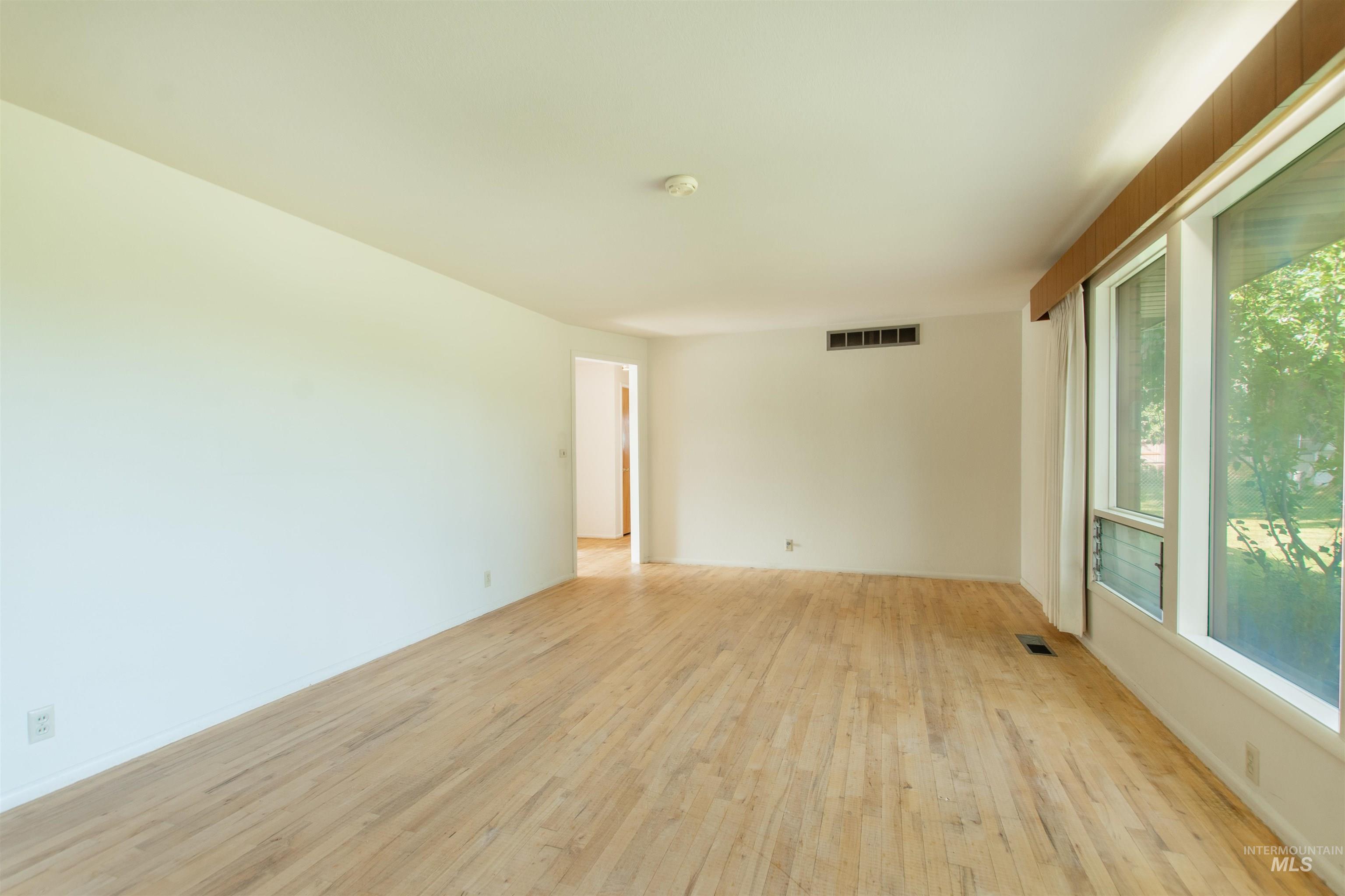2716 North Redway Road Boise, ID 83704 - Photo 19 of 36 Expansive room featuring light wood-finish flooring, large multi-pane windows, and a neutral color palette