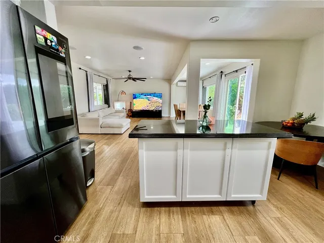 a kitchen with stainless steel appliances granite countertop a refrigerator a stove and a wooden floors