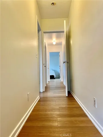 a view of a room with wooden floor and a bathroom