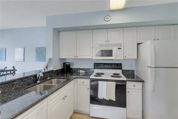 a kitchen with white cabinets sink and white appliances