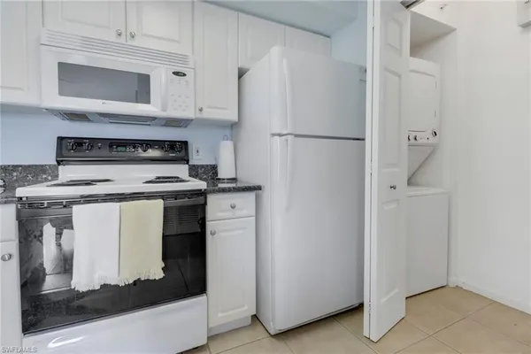 a kitchen with white cabinets and white appliances