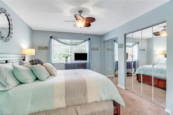 a bedroom with a large bed and a chandelier
