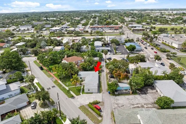an aerial view of residential houses with outdoor space and trees